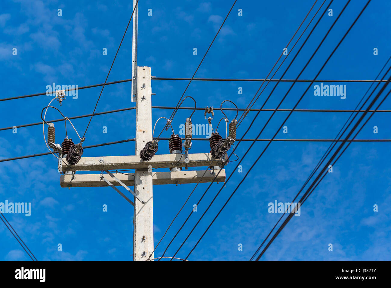 High voltage power pole with wires tangled on blue sky background Stock ...