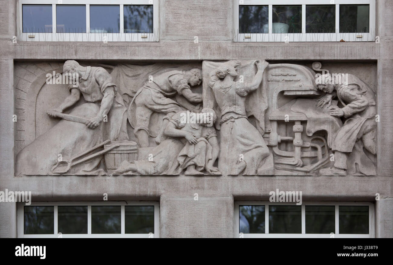 Tannery production. Relief by Hungarian sculptor Laszlo Huvos (1930) on the north wing of the Art Deco building of the Budapest Workers Insurance Fund in Budapest, Hungary. The building, now used as the seat of the National Social Insurance Centre (OTI), was designed by Hungarian architects Marcell Komor and Dezso Jakab and built in 1913. The north wing was added by architect Aladar Sos in 1930-1931. Stock Photo