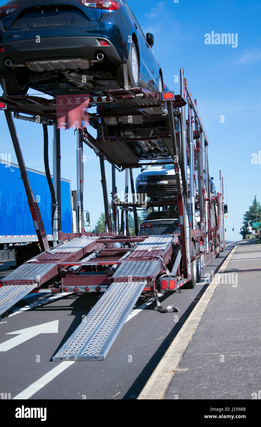 Semi Truck car hauler for transportation of cars with cars on two-level trailer is on the road for unloading trucks with decomposition runners Stock Photo
