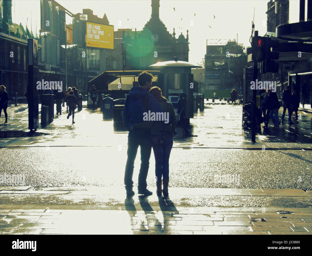 young couple urban style silhouette trendy hipster Glasgow walking holding hands together Stock Photo
