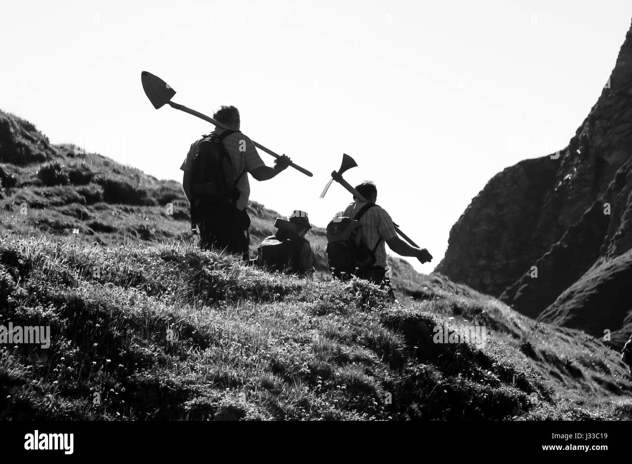 Black and white shot of workers with tools in their hands, hiking in the mountains, Oberstdorf, Germany Stock Photo
