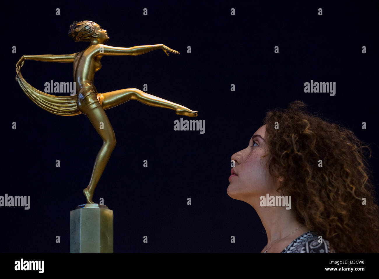 London, UK. 2 May 2017. Bonhams specialist Raphaelle Benabou looks at an art deco silvered bronze and onyx figure of a scarf dancer by Stefan Dakon, est. USD 1,500-2,000.  Bonhams London presents highlights from the forthcoming sale of Jackie Collins estate 'A Life in Chapters' which will take place on 16-17 May 2017 at Bonhams in Los Angeles. Stock Photo