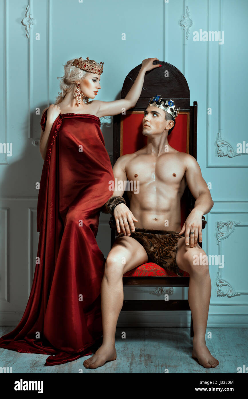 Man sits on the throne and looks at the queen. Crown on their heads. Stock Photo