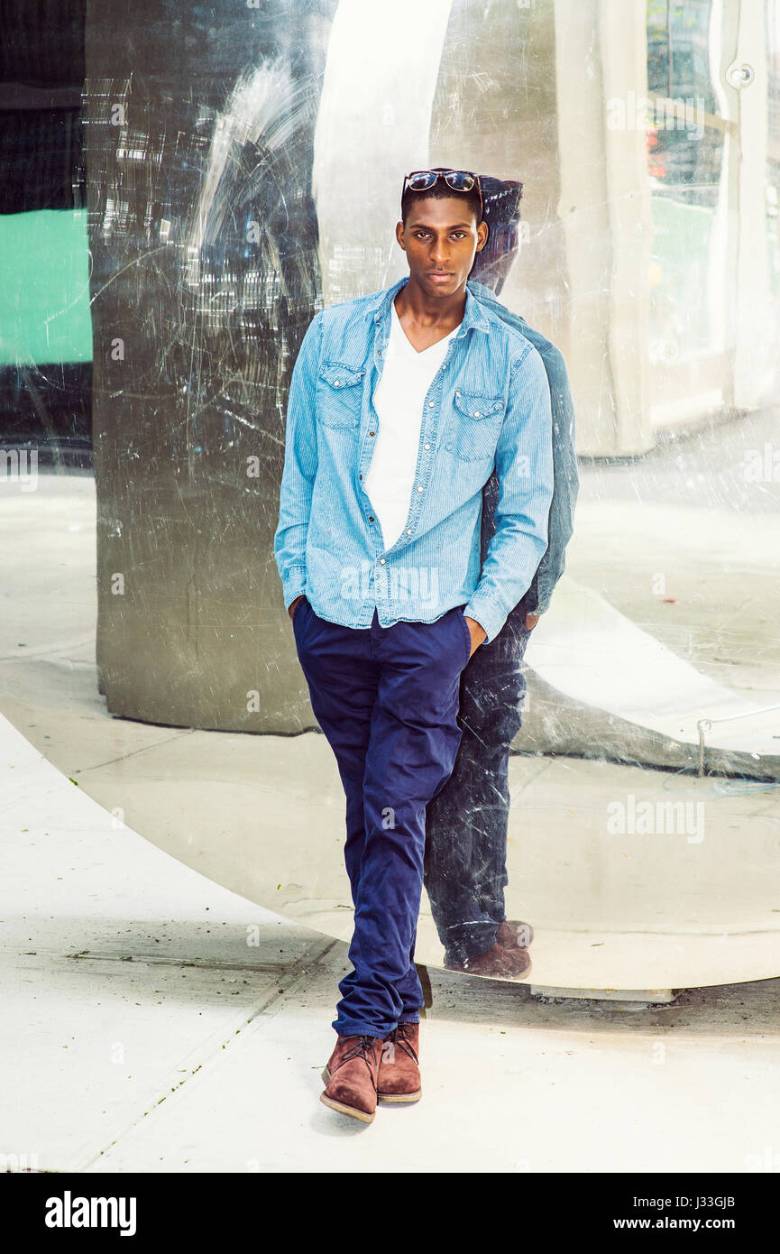 Young African American Man Casual Fashion in New York, wearing light blue  long sleeve casual shirt, blue pants, brown boot shoes, glasses on head,  sta Stock Photo - Alamy