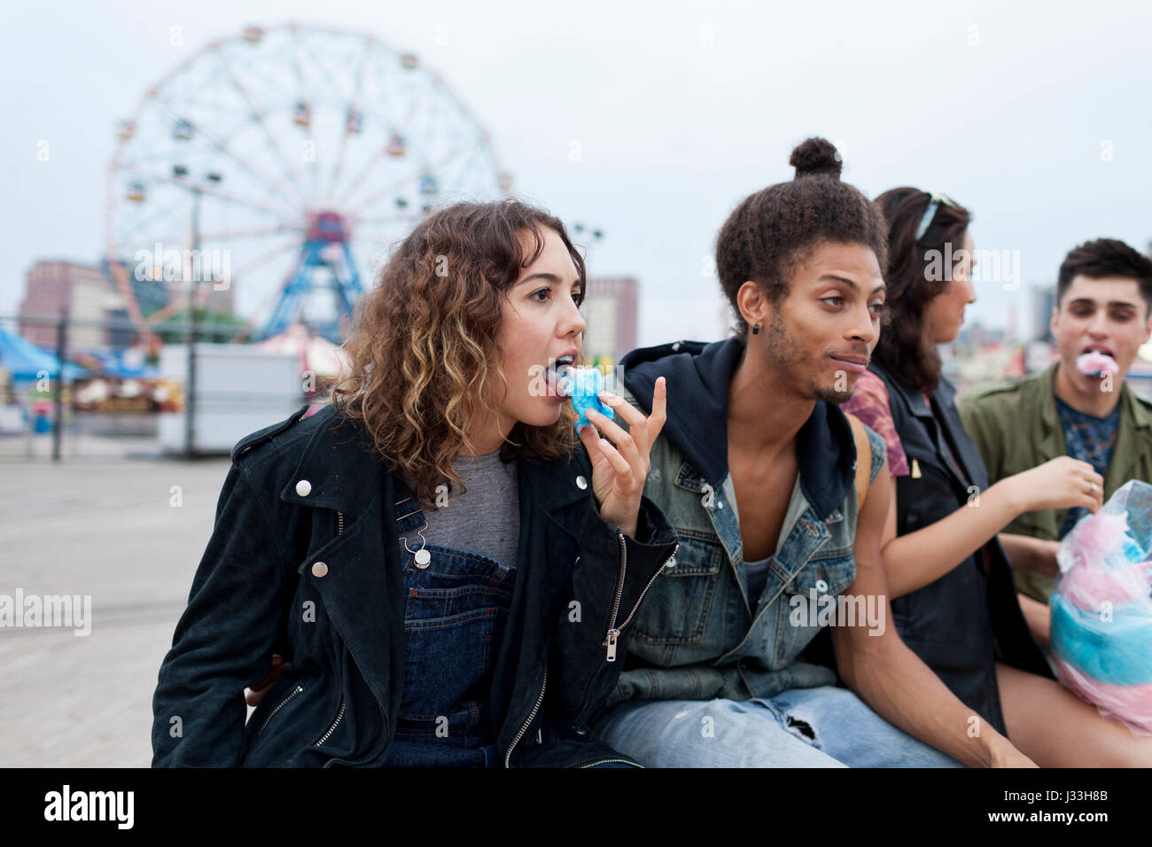 Friends eating cotton candy at an amusement park Stock Photo - Alamy