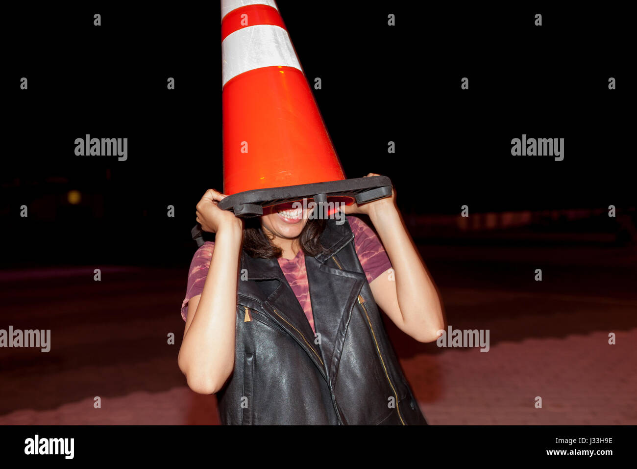 Playful young woman with a traffic cone on her head Stock Photo Alamy