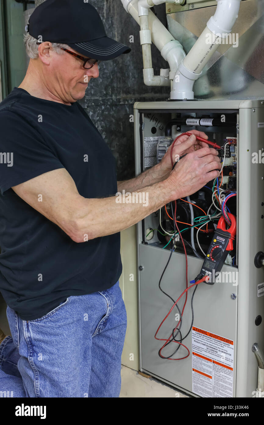 Furnace Repairman Servicing High Efficiency Heating Unit Stock Photo
