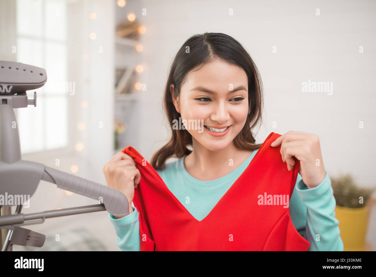 A lovely asian girl trying on new dress at home. Stock Photo