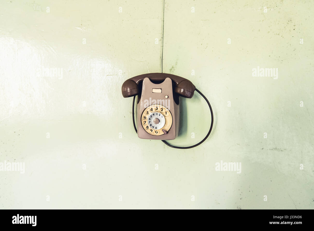 vintage phone on the wall - objects and places lost in time Stock Photo