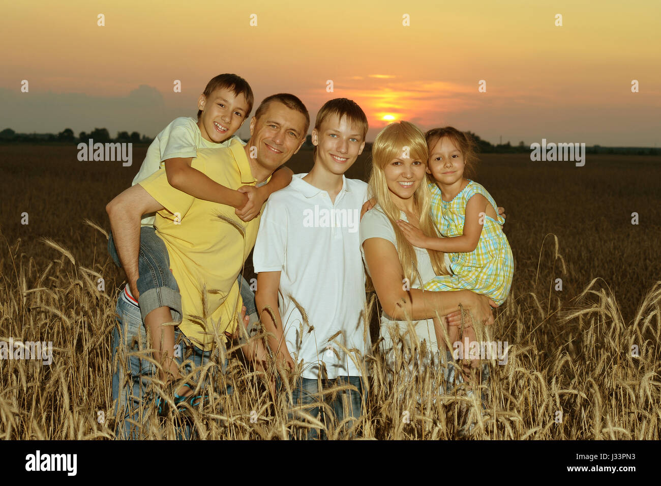 Happy parents with children at sunset Stock Photo