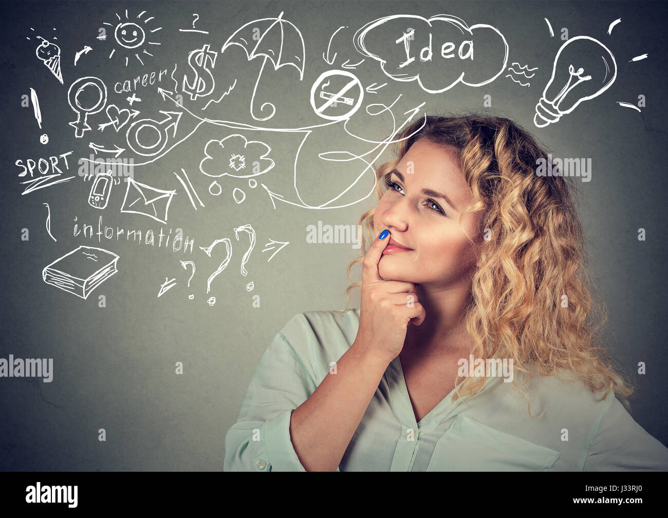 Portrait happy young woman thinking dreaming has many ideas looking up isolated grey wall background. Positive human face expression emotion feeling l Stock Photo