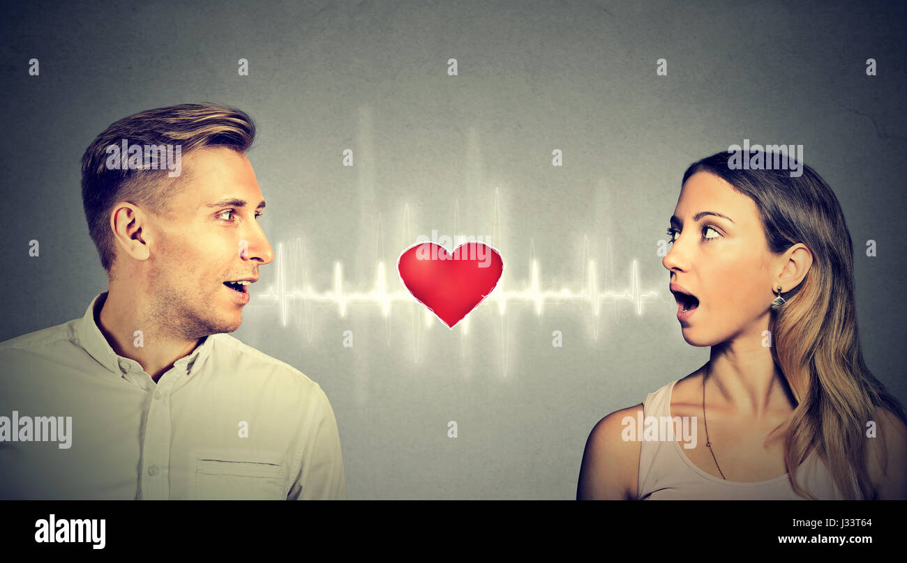 Love connection. Man woman talking to each other with red heart in-between Stock Photo