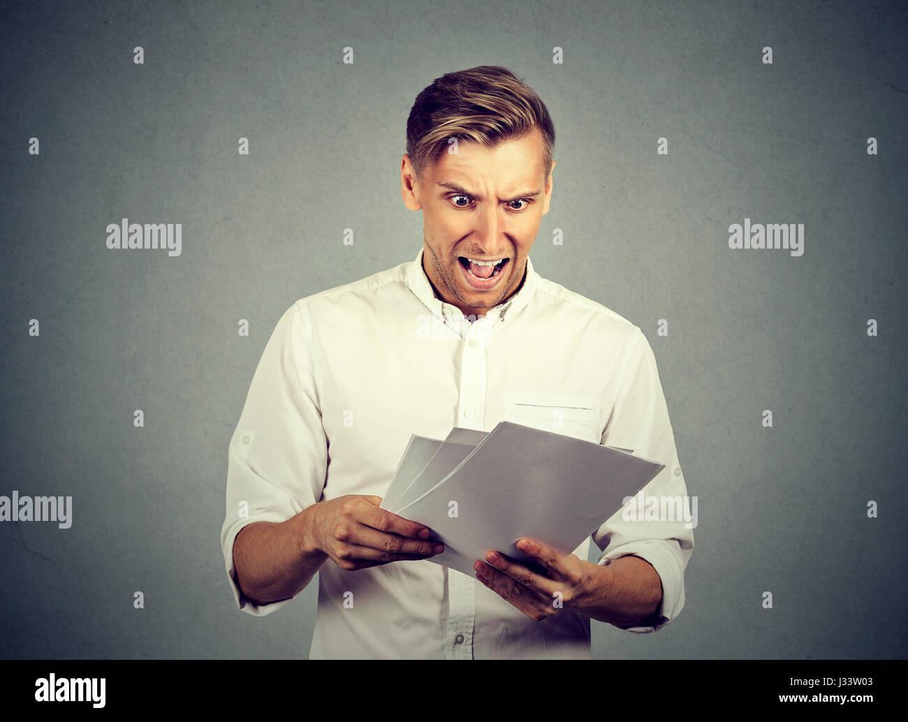 Angry businessman with documents Stock Photo - Alamy