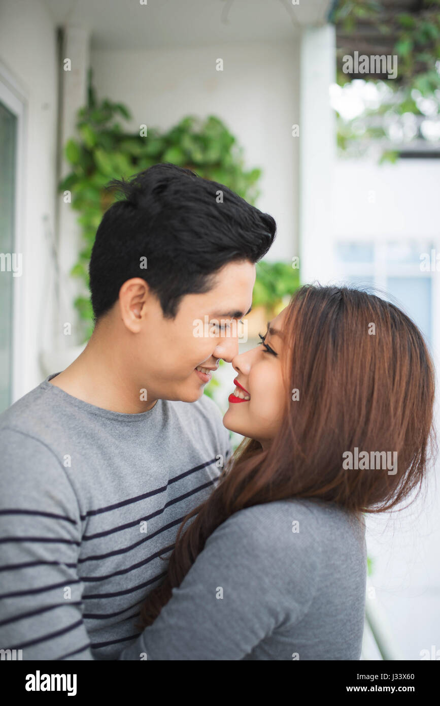 Couple in love sharing genuine emotions and happiness, hugging on the balcony Stock Photo