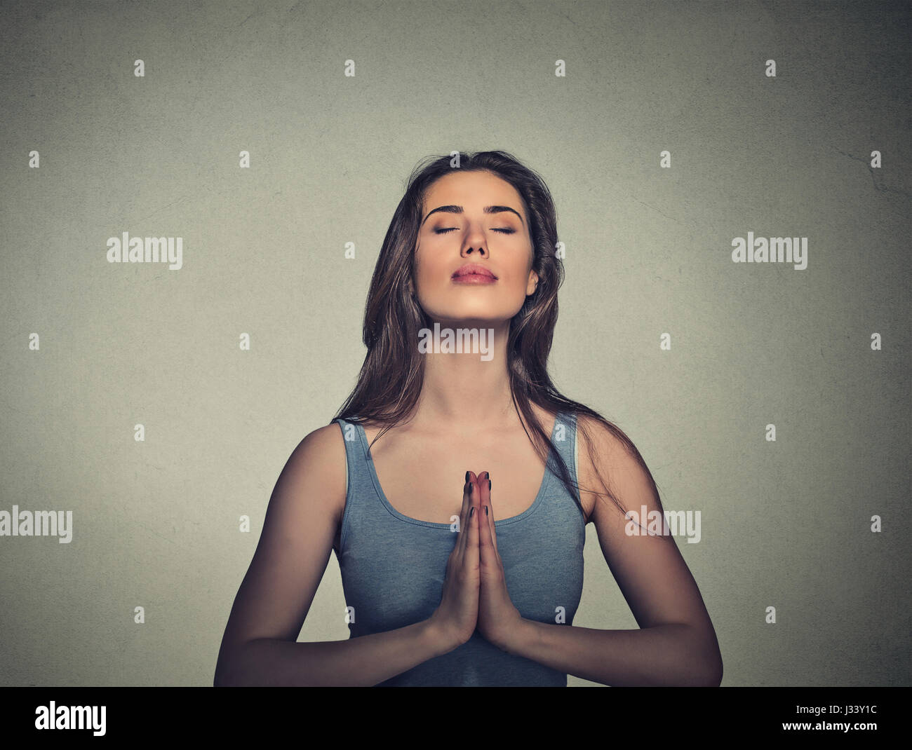 Portrait beautiful woman meditating with eyes closed isolated on gray ...