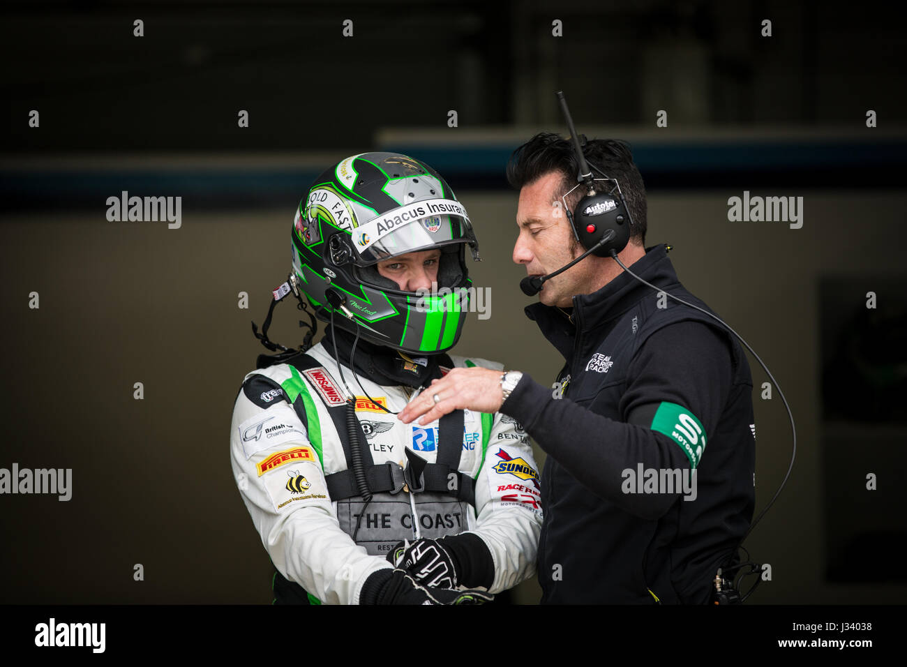 Callum Macleod talking to his crew chief in pit lane at Rockingham Speedway during British GT Stock Photo