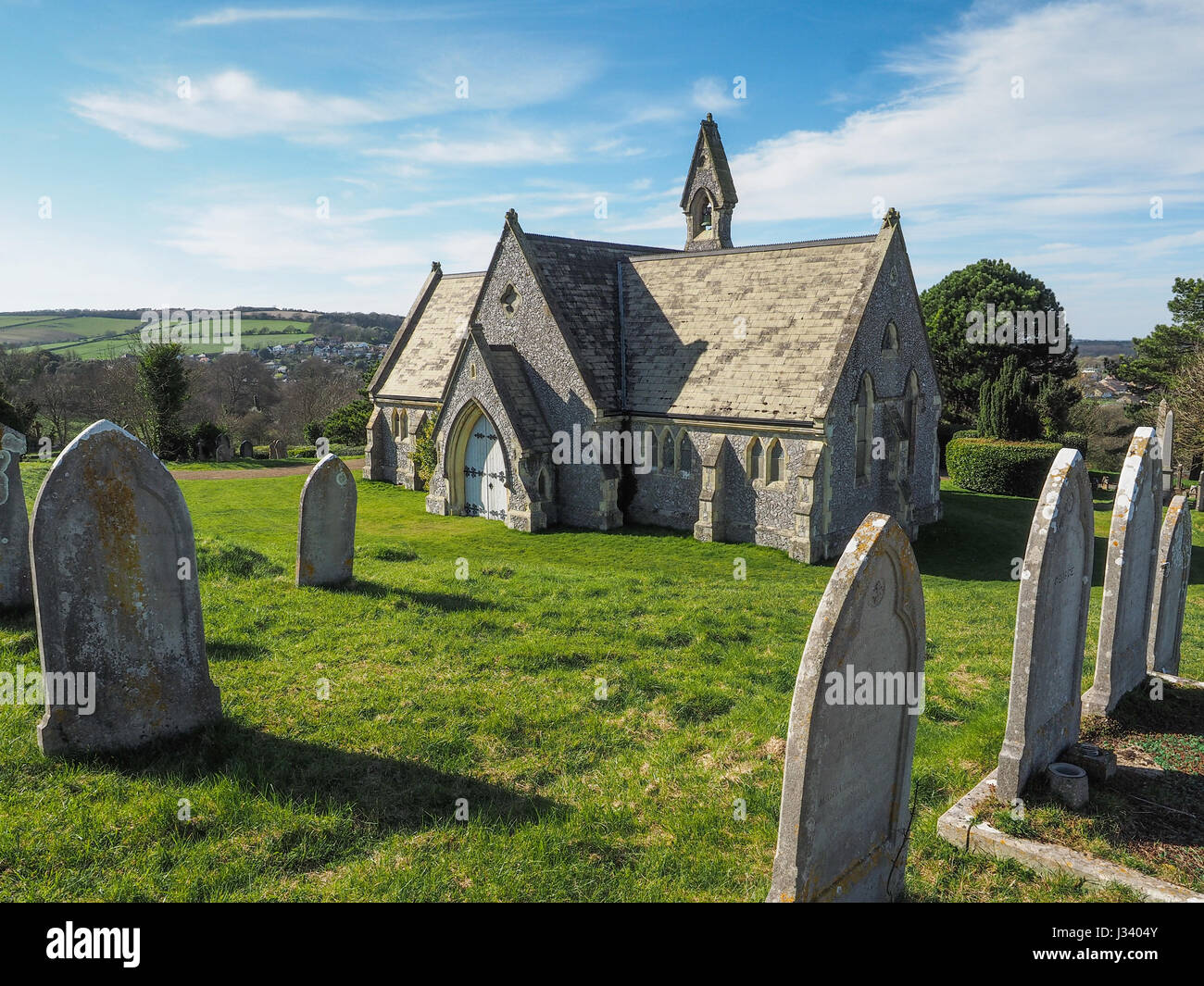 Mount Joy Cemetery Chapel Newport Isle of Wight sunny day light wispy cloud gravestones headstones in foreground strong shadow Stock Photo