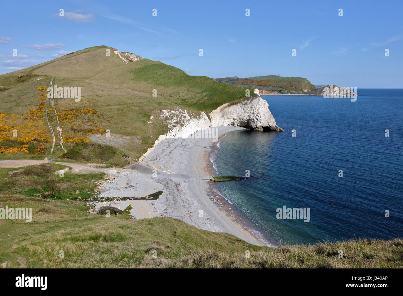 South West Coast path across Lulworth ranges give magnificent views of the terrain and white chalk cliffs bounding Arish Mell, Dorset UK Stock Photo