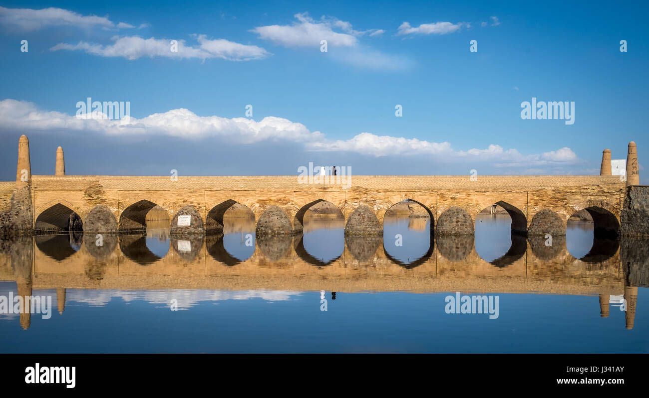 Two Iranian women with black and White chador walking on Varzaneh's Old Bridge Stock Photo