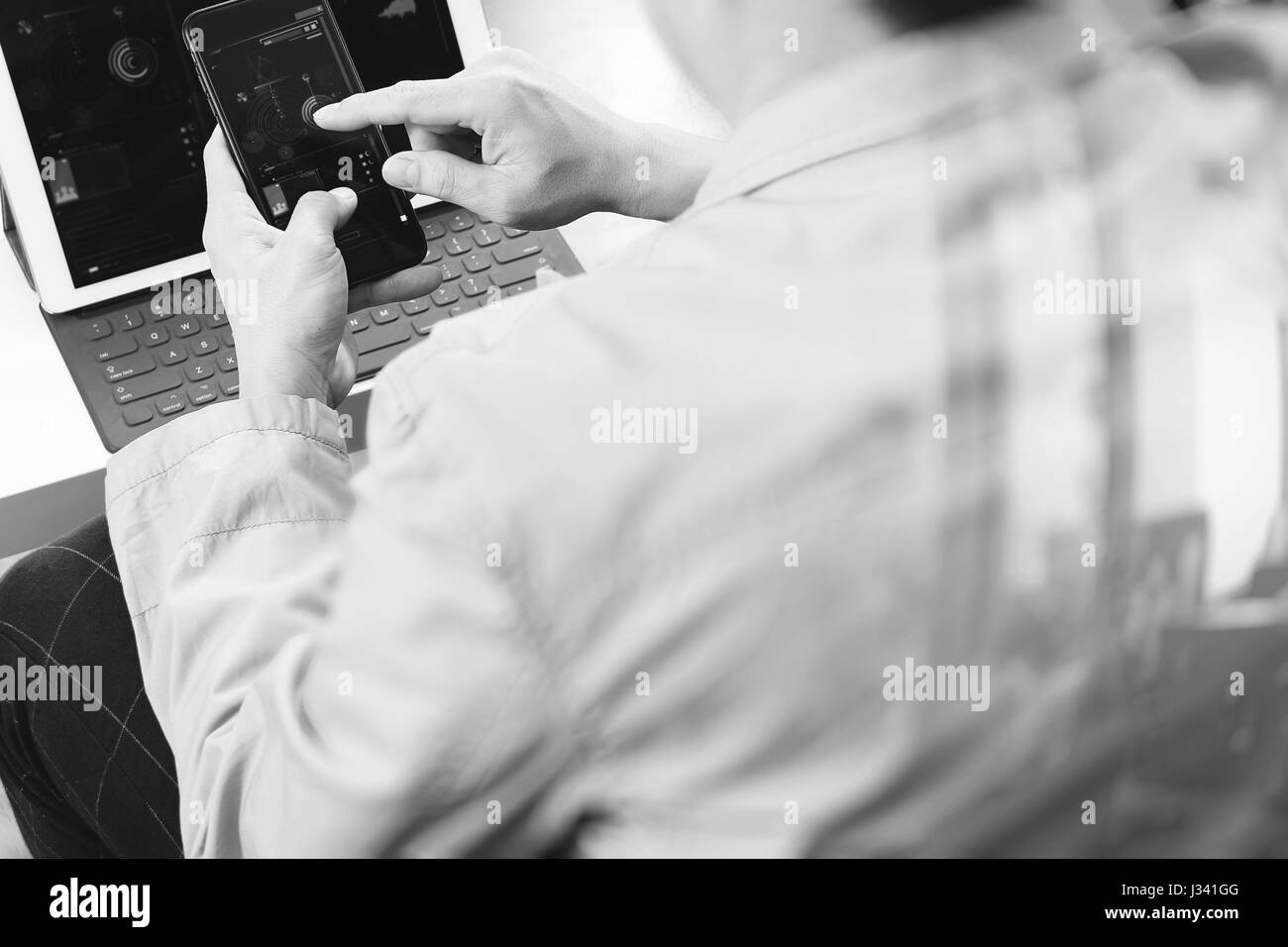 hand using smart phone and digital tablet computer for online banking payment communication in modern office,black and white Stock Photo