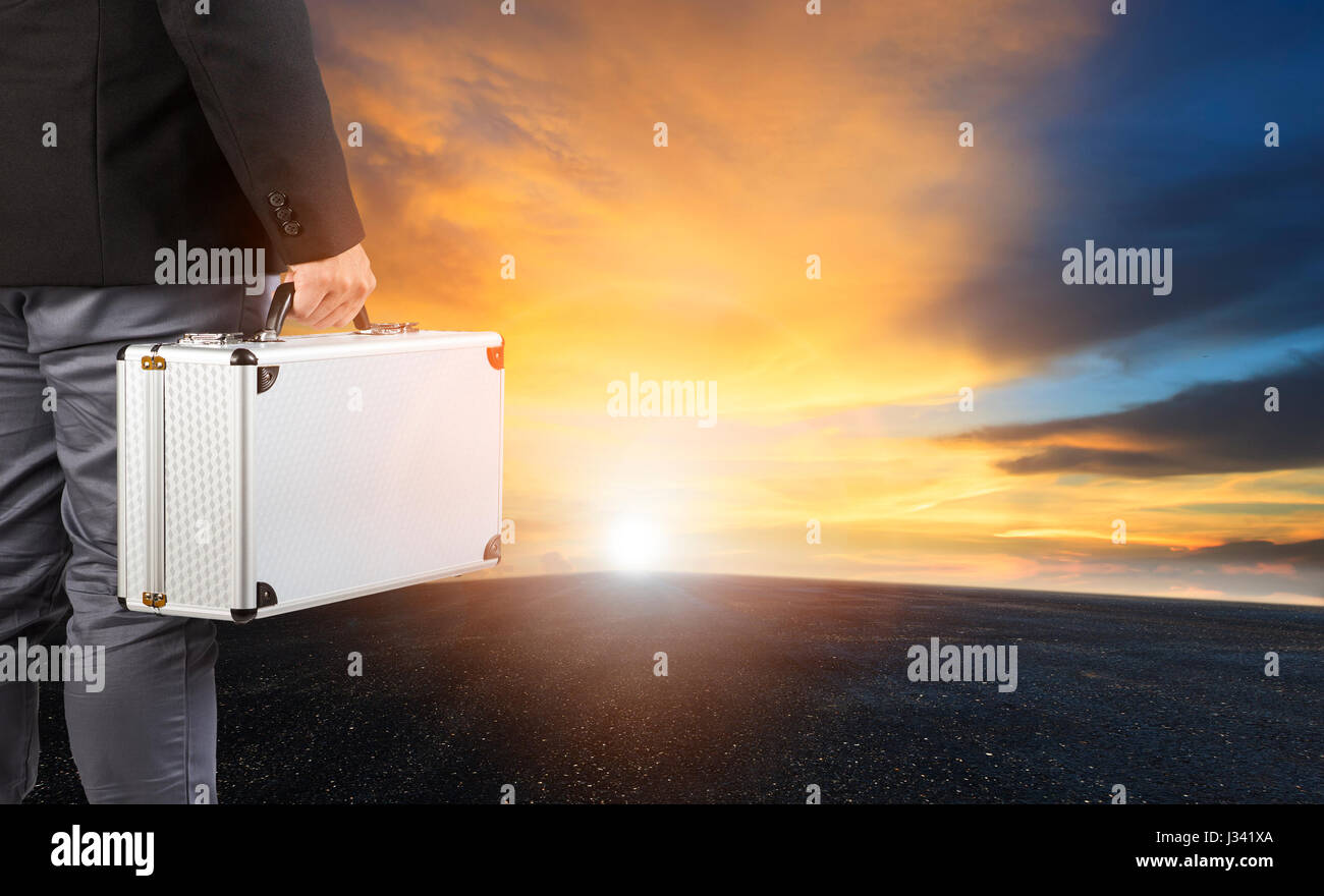 business man and steel breifcase standing on wide road and sun rising sky for business opportunity concept Stock Photo