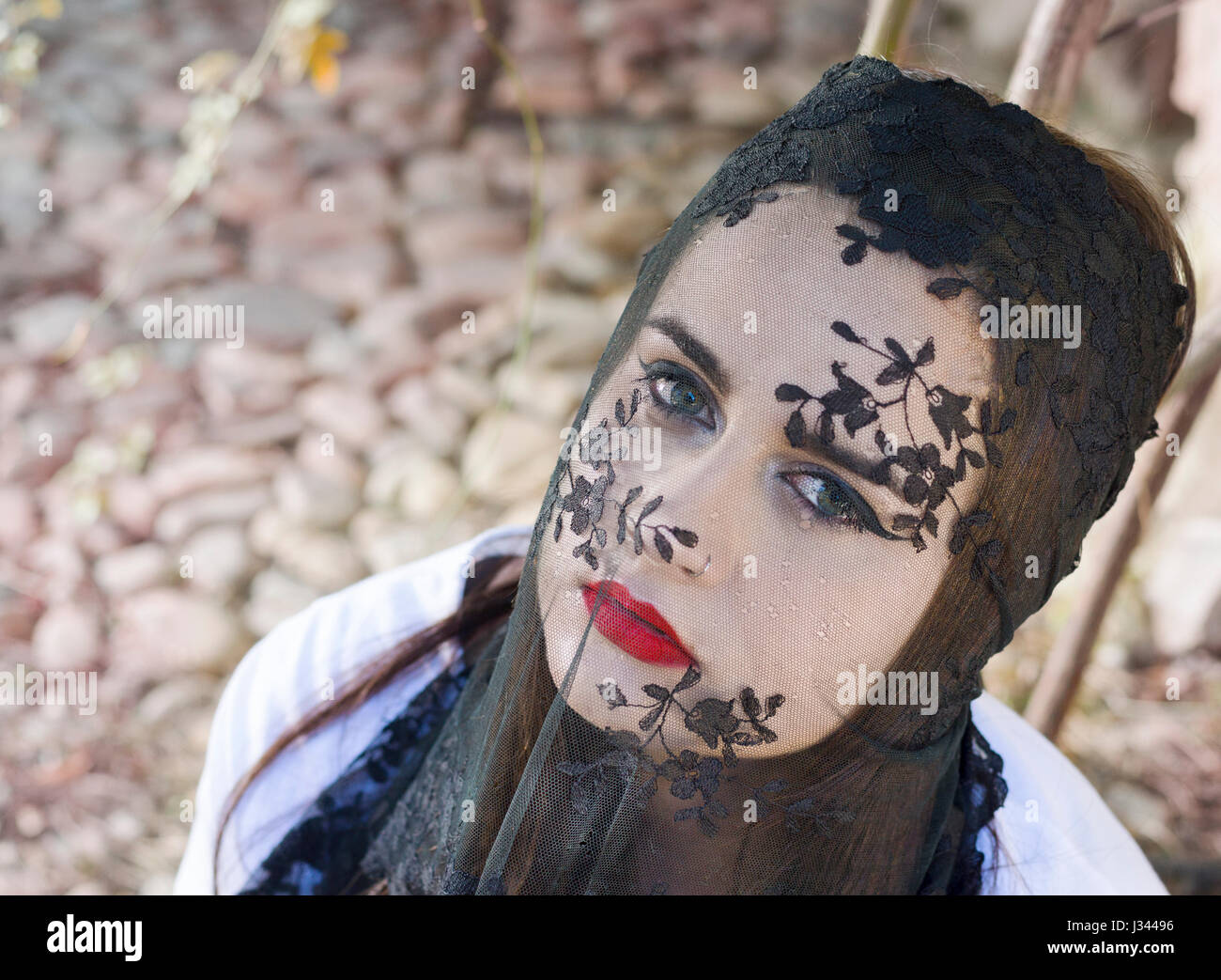 Woman wearing black and  translucent veil over her face. Stock Photo