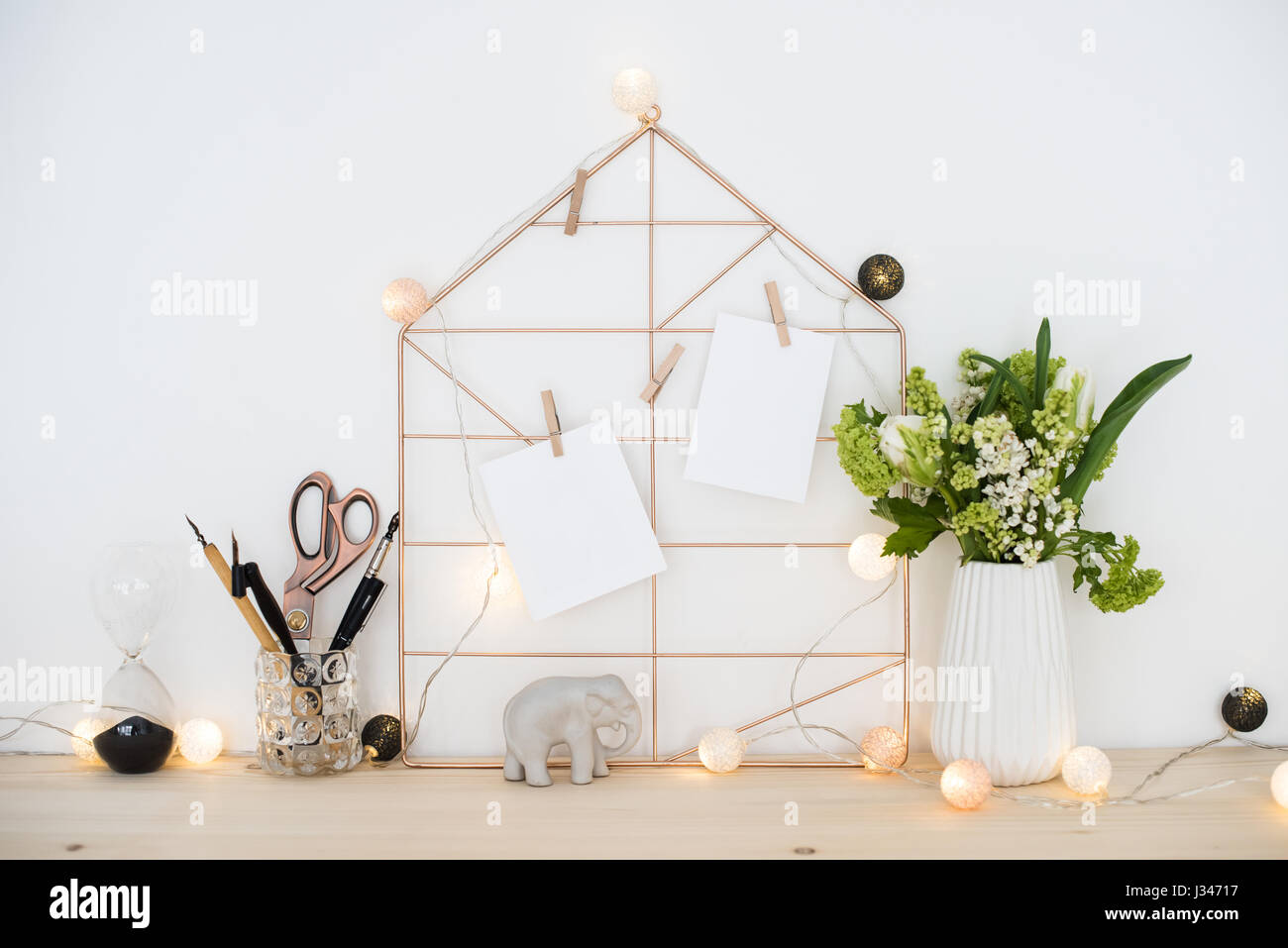 Feminine hipster office table decoration with flowers and mood board on