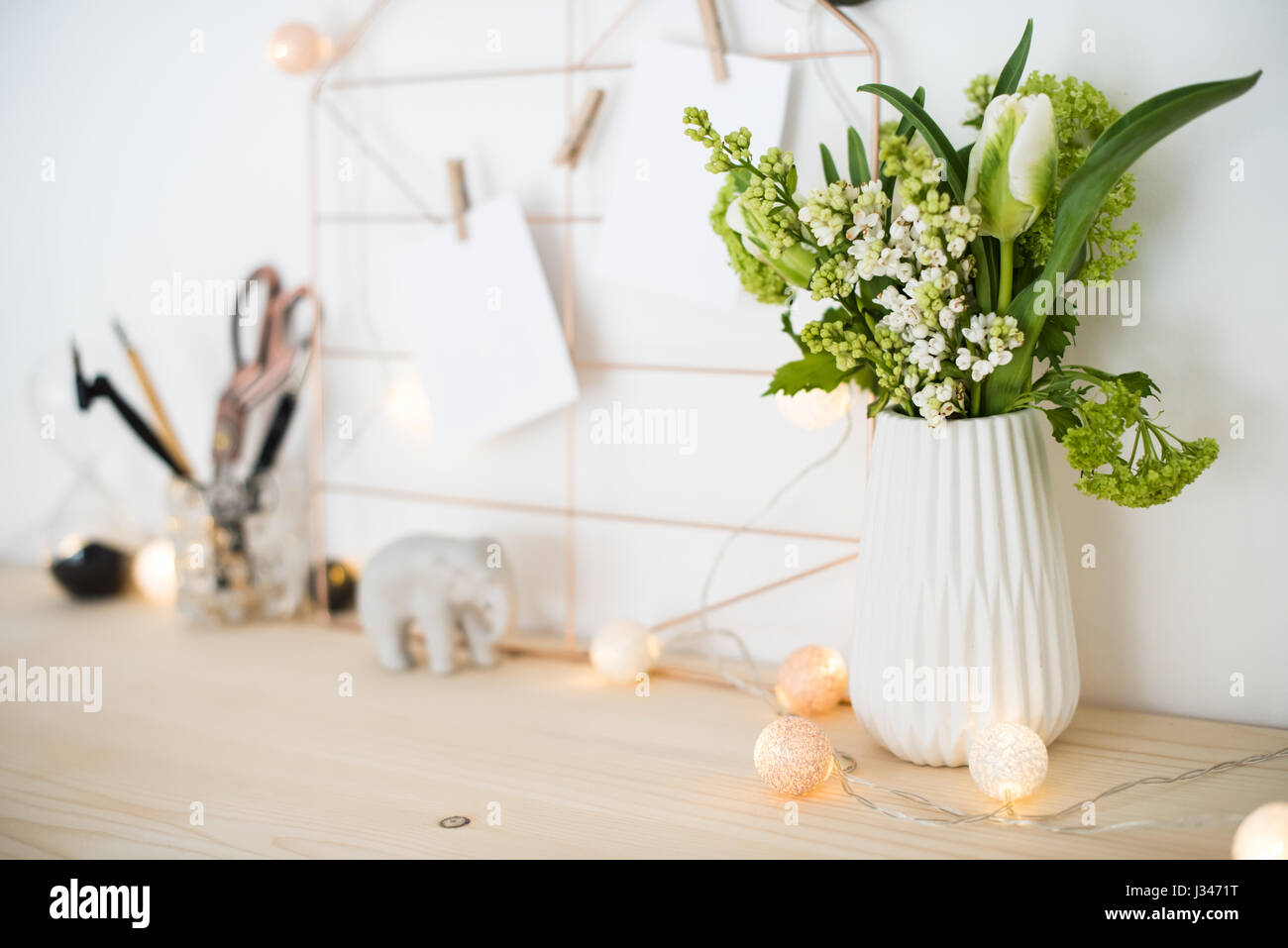 Feminine hipster office table decoration with flowers and mood board on