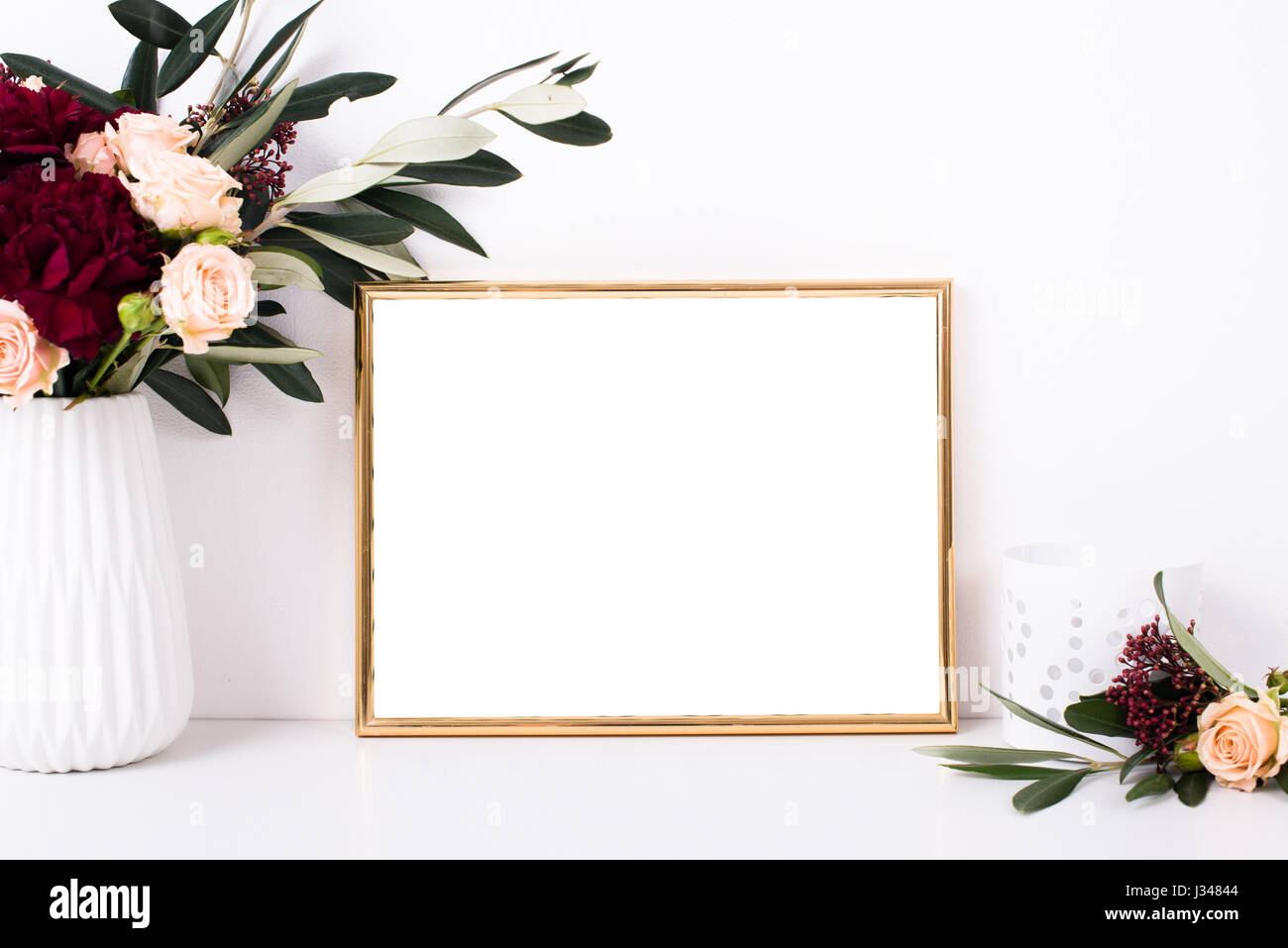 Golden frame mock-up on white wall background, home decor with flowers and objects Stock Photo