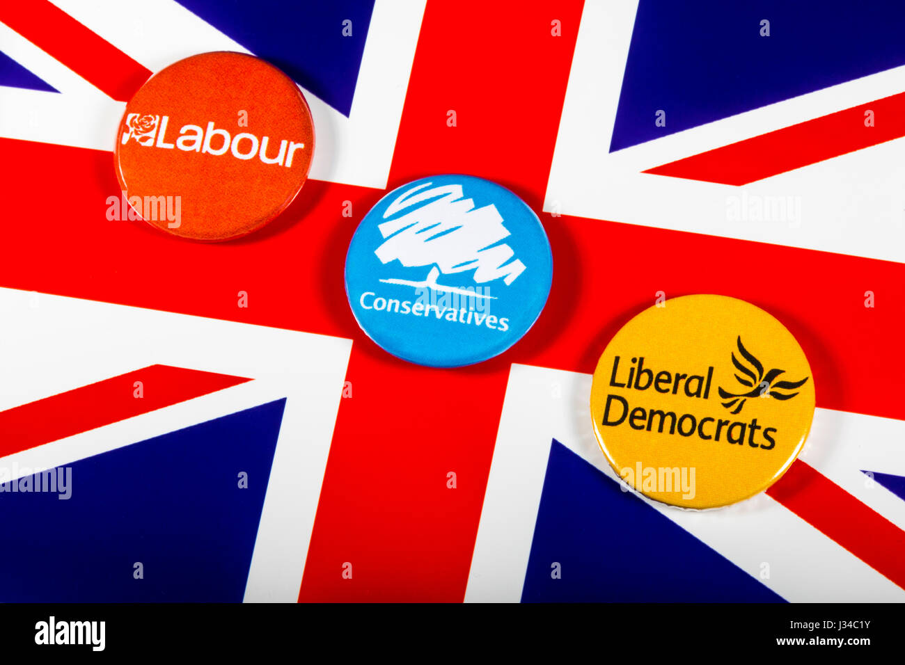 LONDON, UK - MAY 2ND 2017: Labour, Conservatives and Liberal Democrat pin badges over the UK flag, symbolizing the political battle for the General El Stock Photo