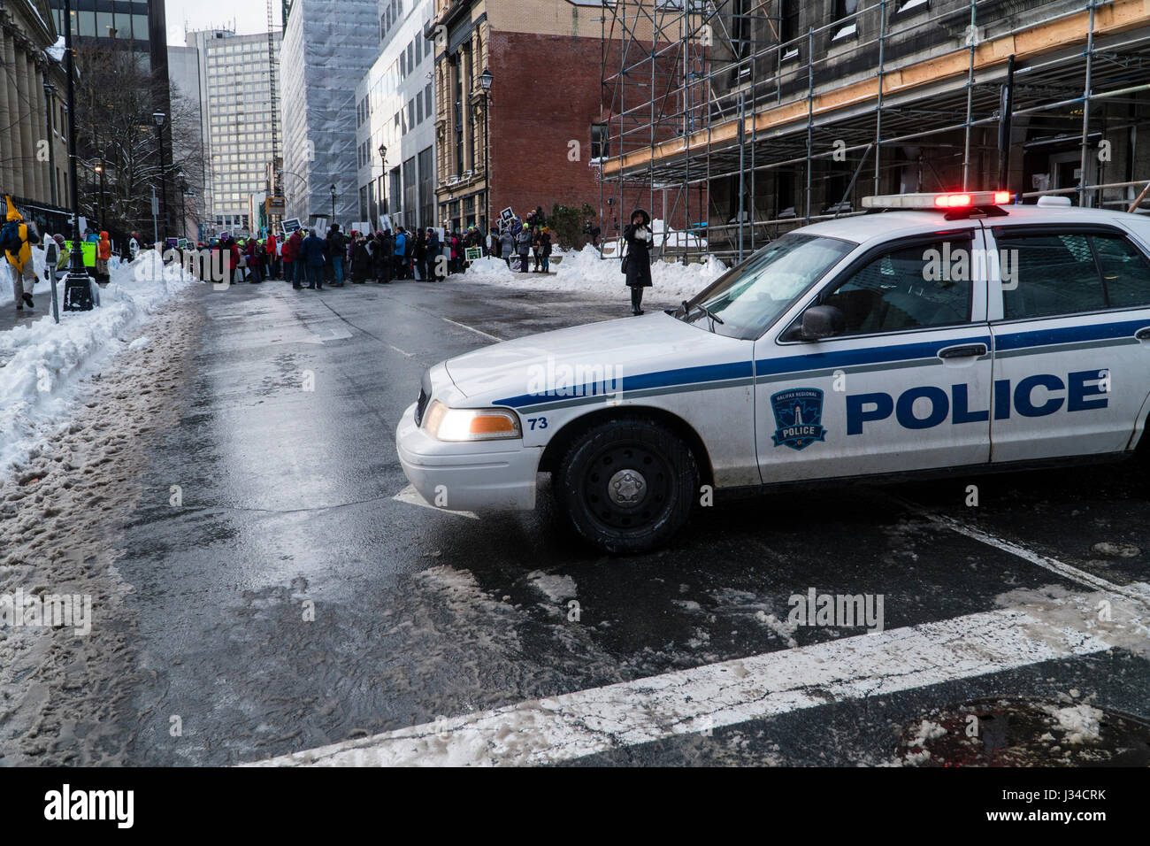 Police car with flashing lights watches over a group of protesting teachers in Halifax, Nova Scotia, Canada. Stock Photo
