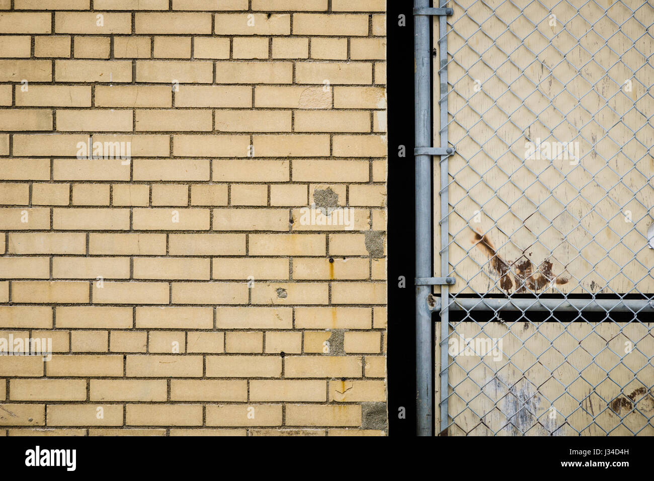 Brick wall meets chain link fence gate on a building in downtown