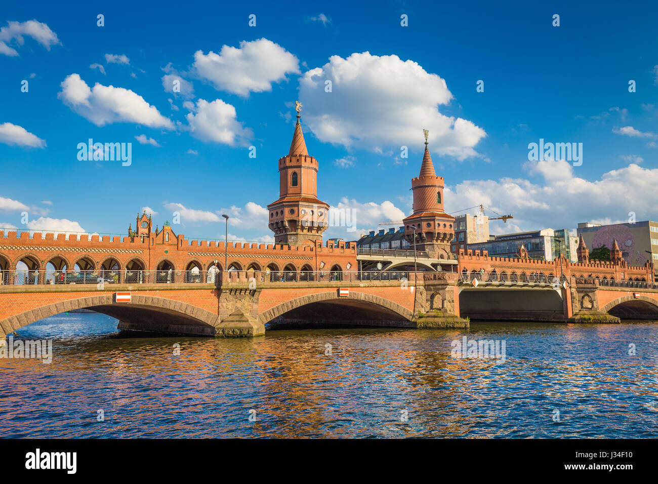 Beautiful view of famous Oberbaum Bridge crossing the Spree river on a sunny day with blue sky and clouds in summer, Berlin, Germany Stock Photo