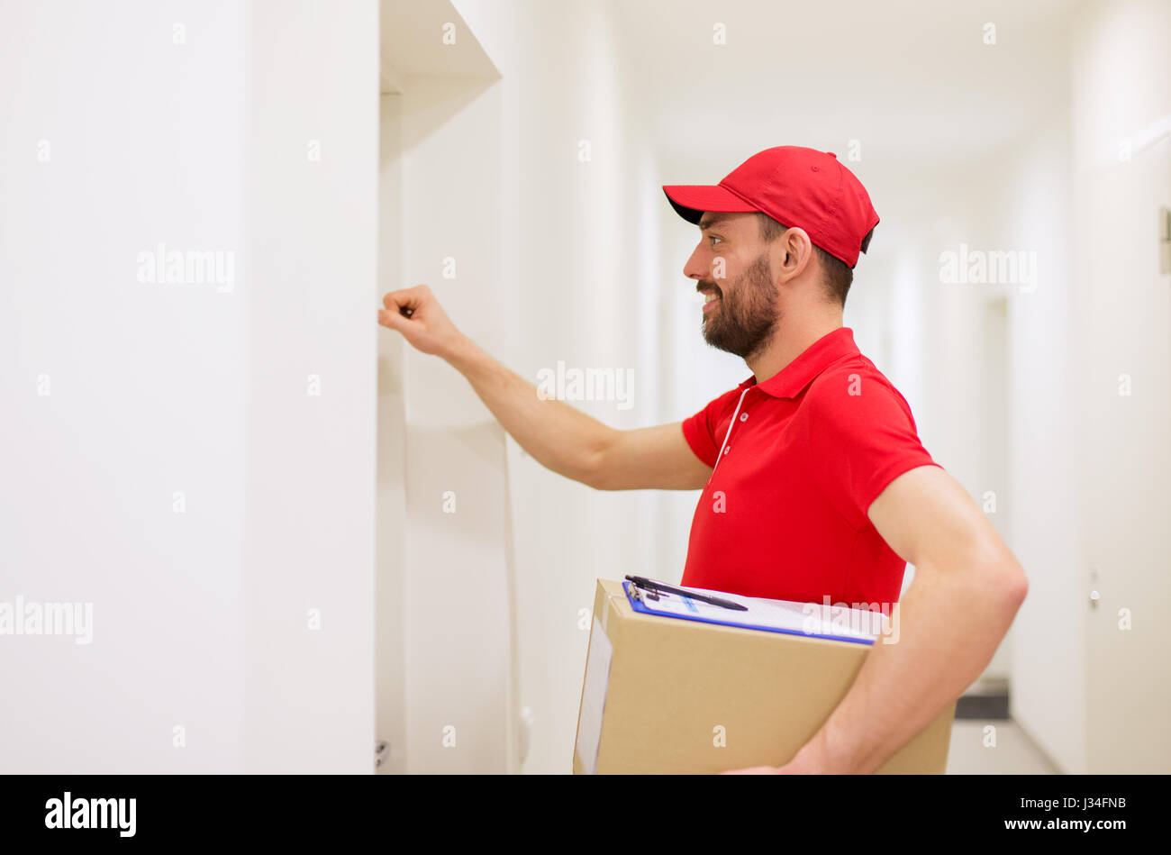 delivery man with parcel box knocking on door Stock Photo