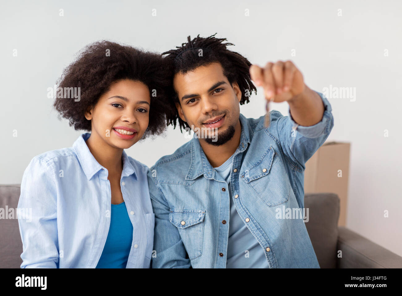 happy couple with key and boxes moving to new home Stock Photo - Alamy