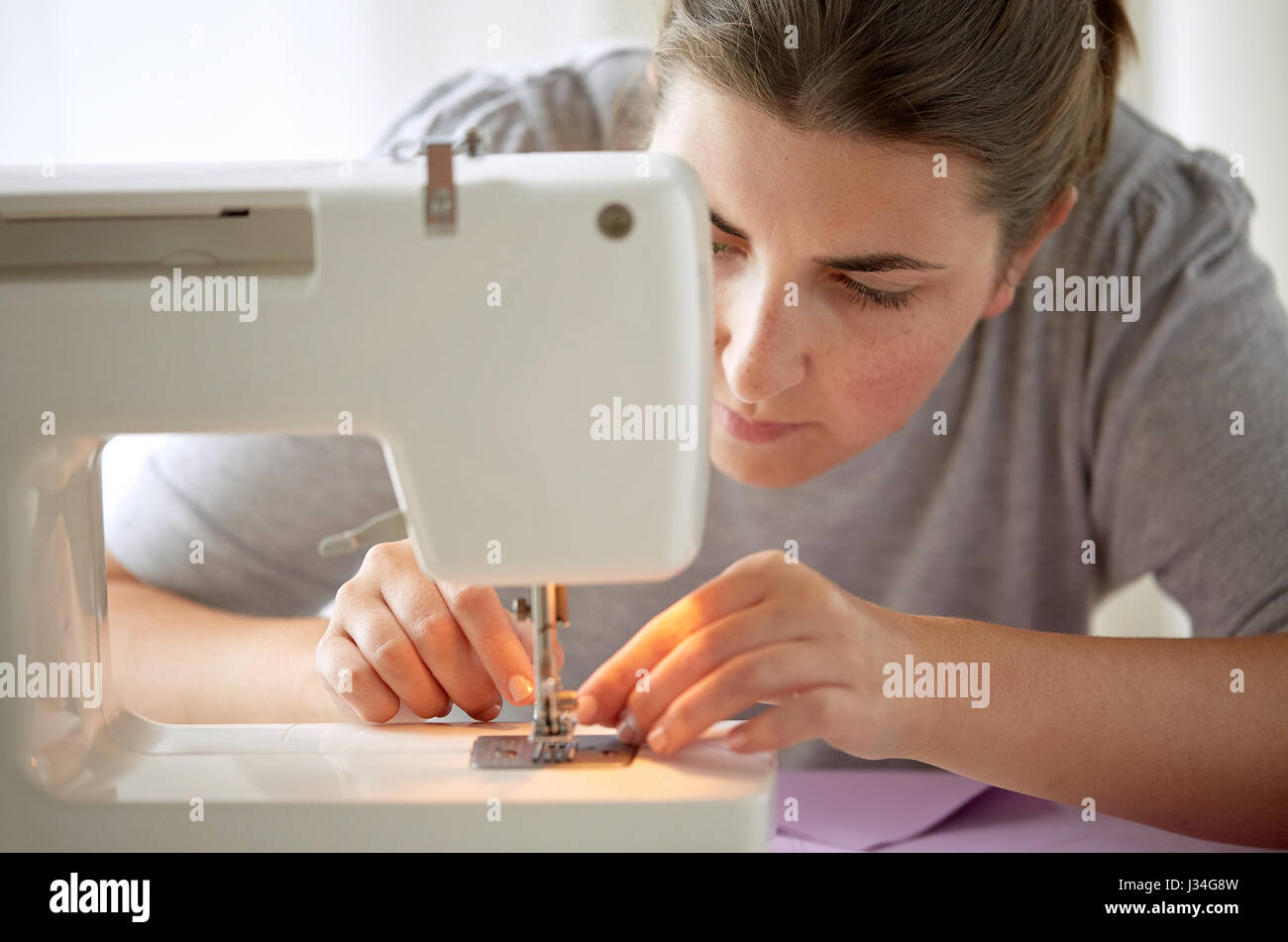 tailor woman threading needle of sewing machine Stock Photo Alamy
