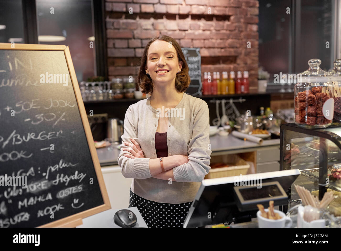 happy woman or barmaid at cafe counter Stock Photo