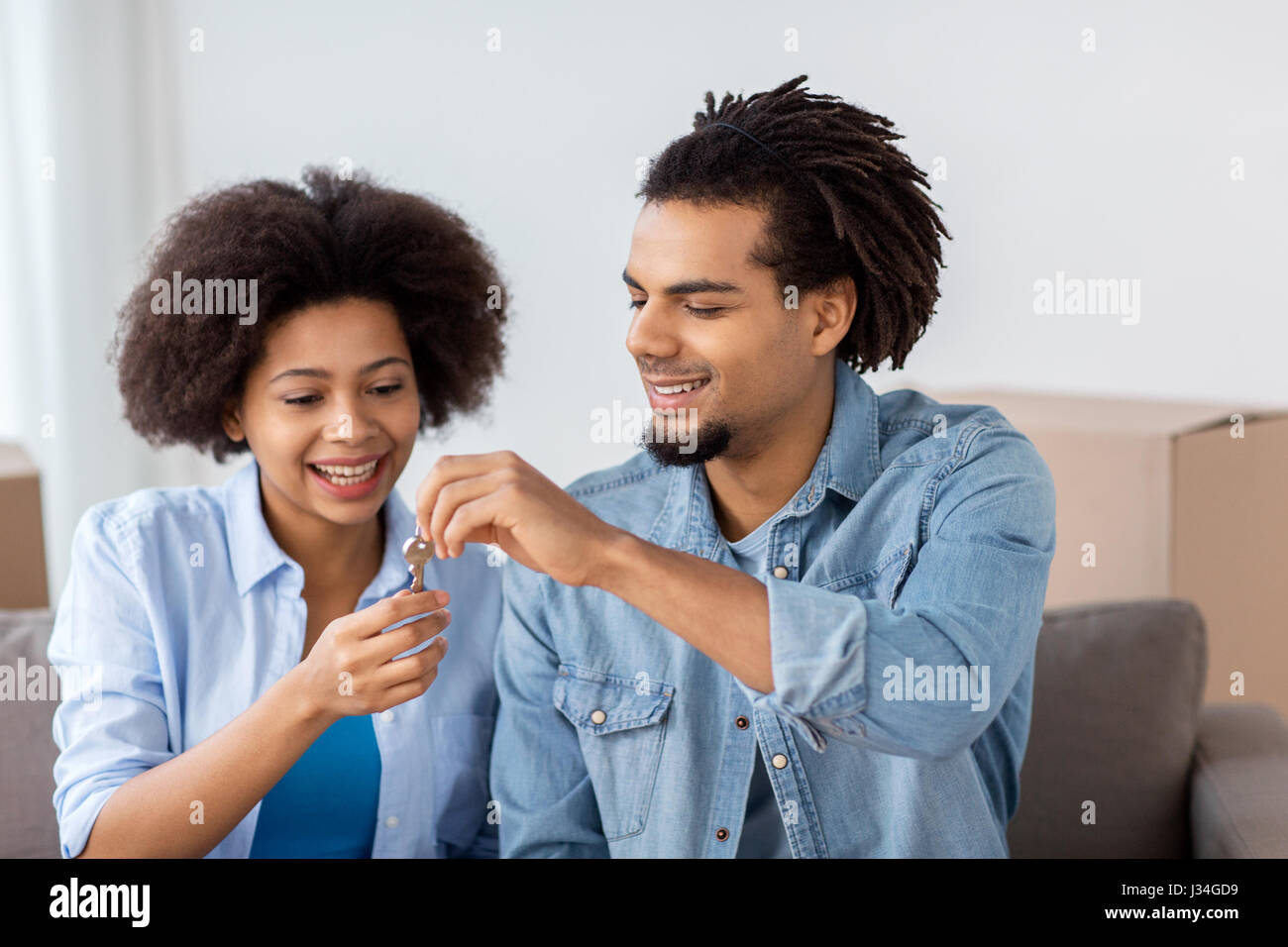 happy couple with key and boxes moving to new home Stock Photo - Alamy