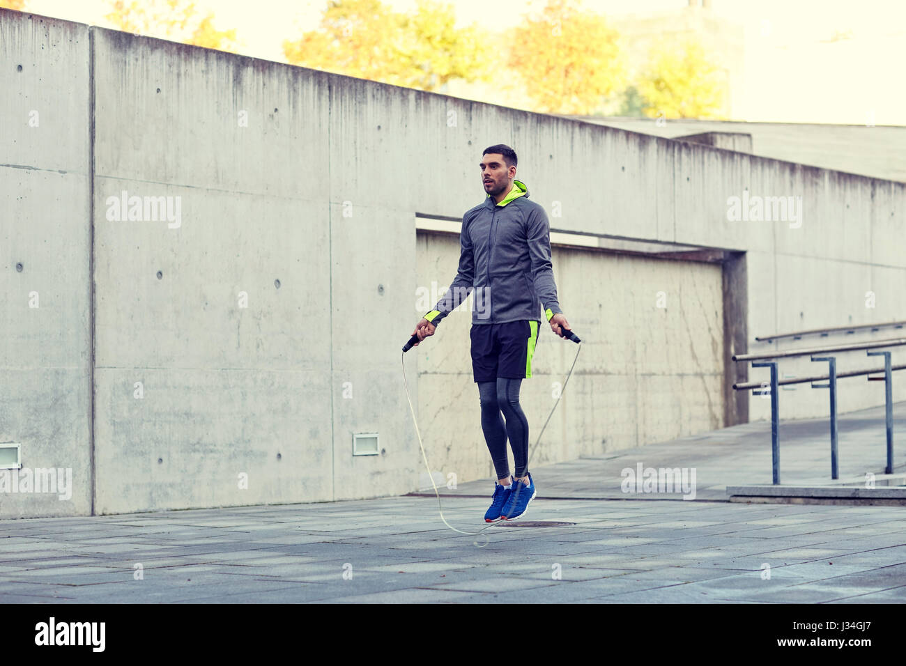man exercising with jump-rope outdoors Stock Photo