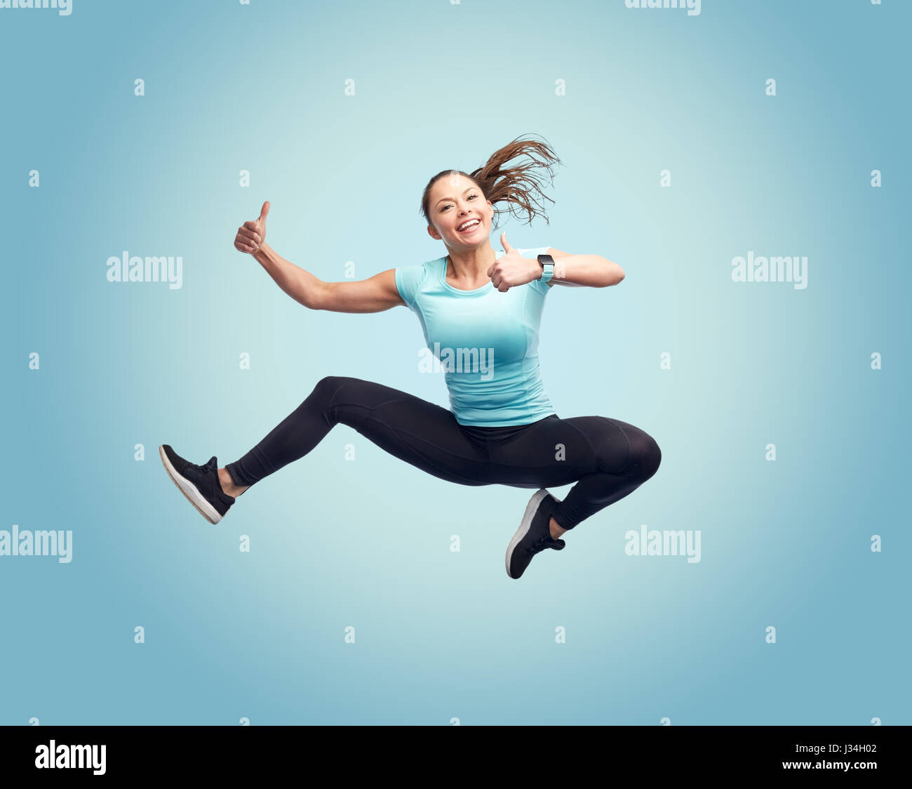 happy smiling sporty young woman jumping in air Stock Photo - Alamy