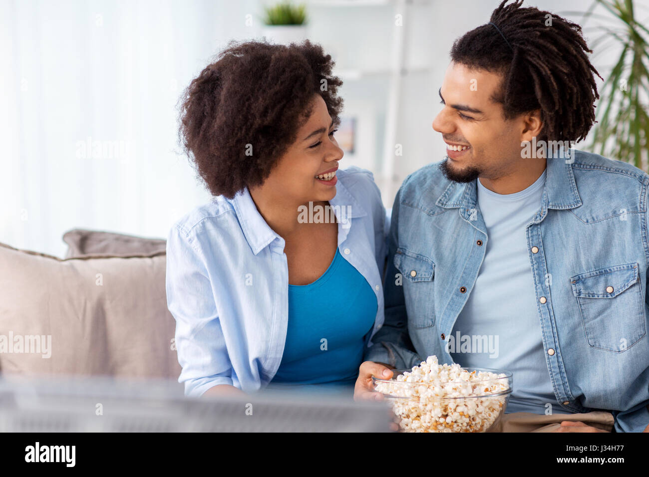 smiling couple with popcorn watching tv at home Stock Photo - Alamy