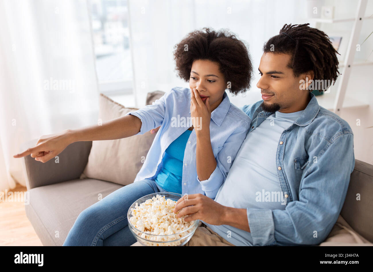 couple with popcorn watching tv at home Stock Photo - Alamy