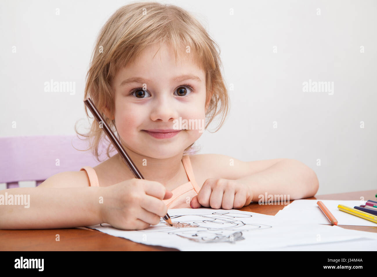 https://c8.alamy.com/comp/J34M4A/little-girl-drawing-with-colored-pencils-on-paper-J34M4A.jpg