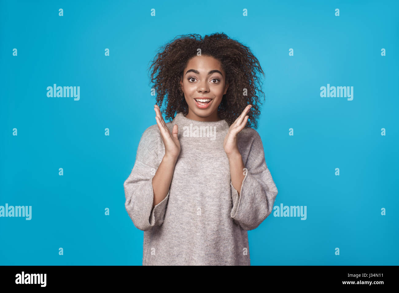 Young african woman studio portrait isolated on blue Stock Photo - Alamy