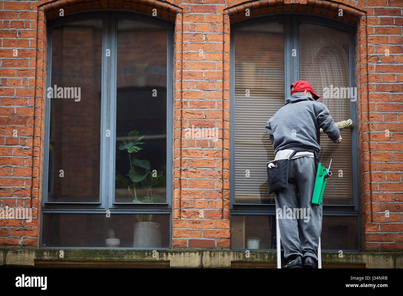 Manchester city centre apartment window cleaner on ladders. Stock Photo
