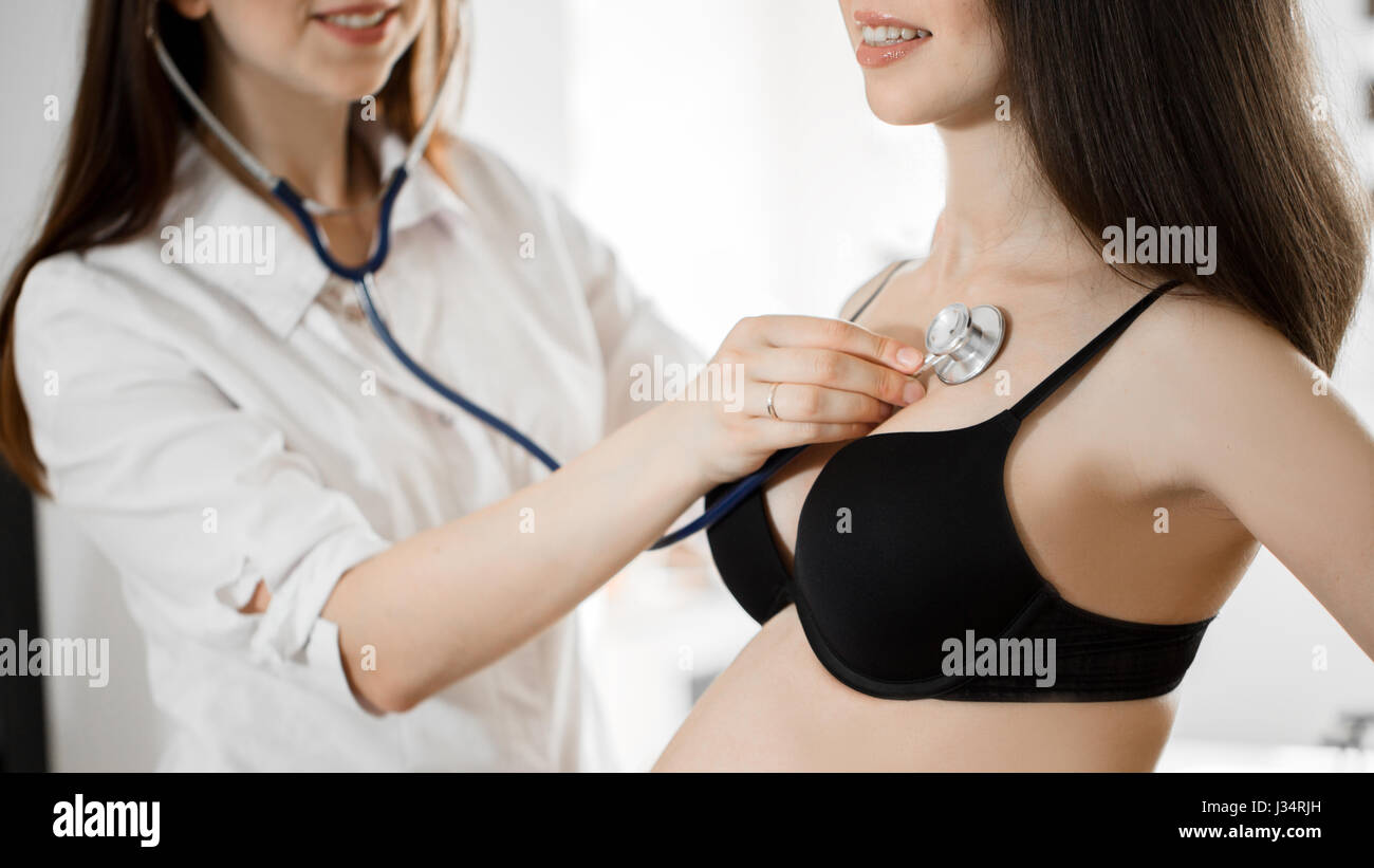 female medicine doctor holding stethoscope to pregnant woman standing for encouragement, empathy, cheering,support, medical examination. New life of a Stock Photo