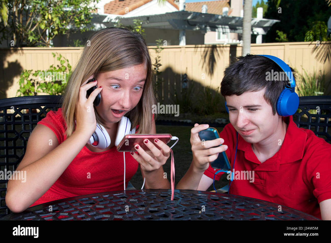 Model released image of young caucasian girl and boy, kids with technology phone game system music social media Stock Photo