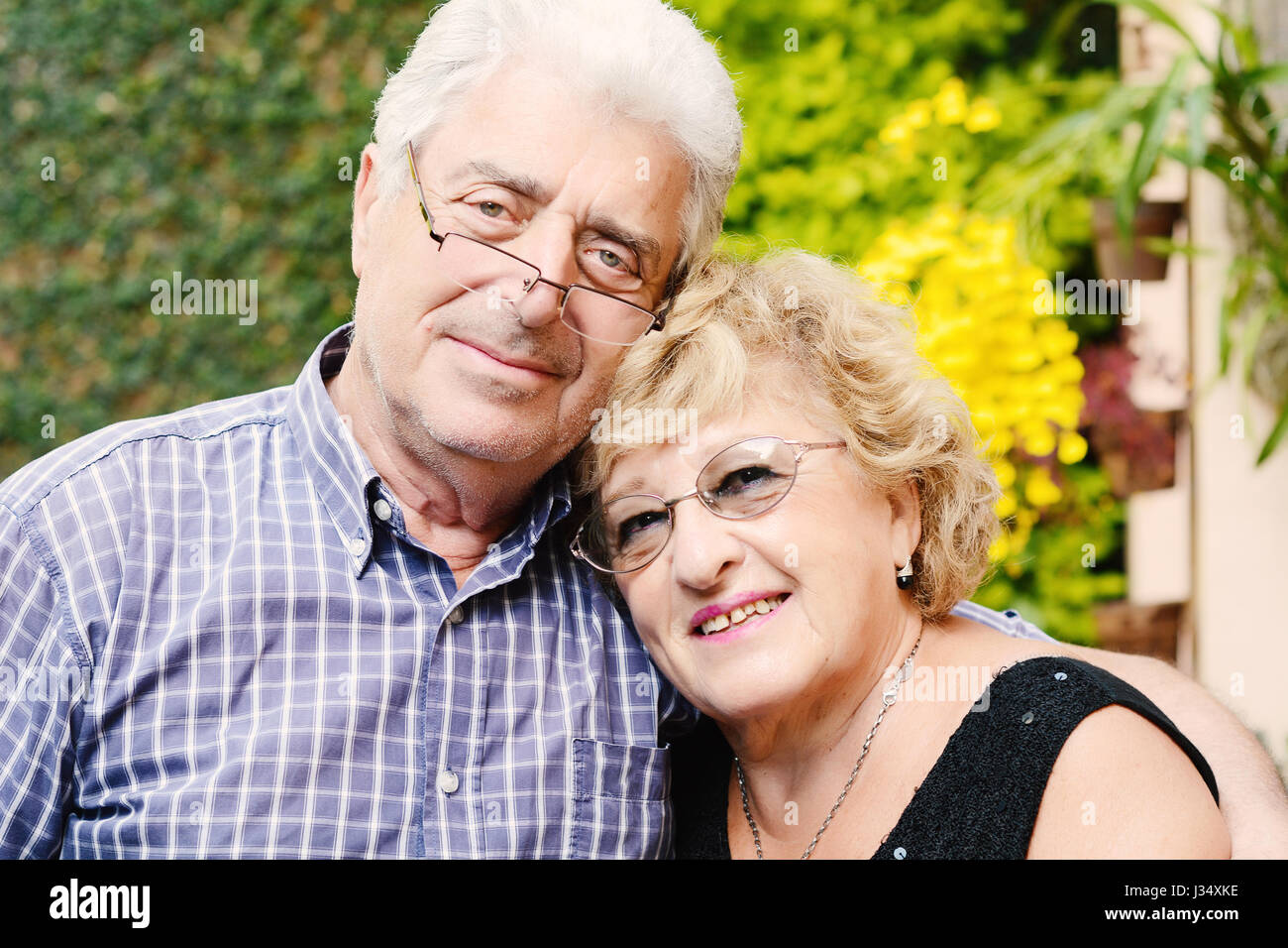Portrait of an elderly couple sitting outdoors Stock Photo - Alamy