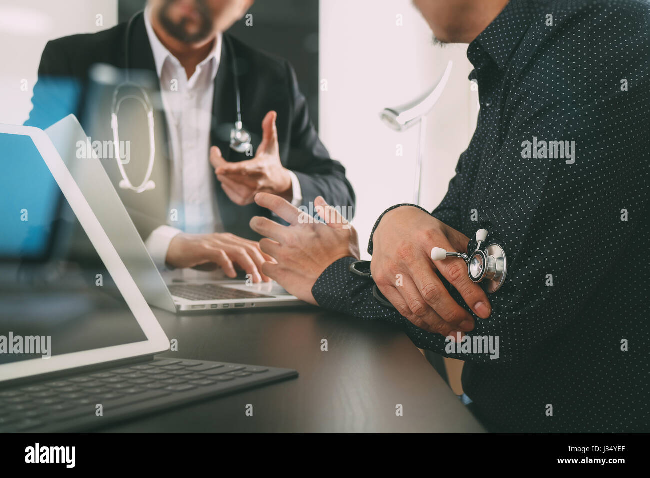 Medical co working concept,Doctor working with digital tablet and laptop computer formeeting his team in modern office at hospital Stock Photo