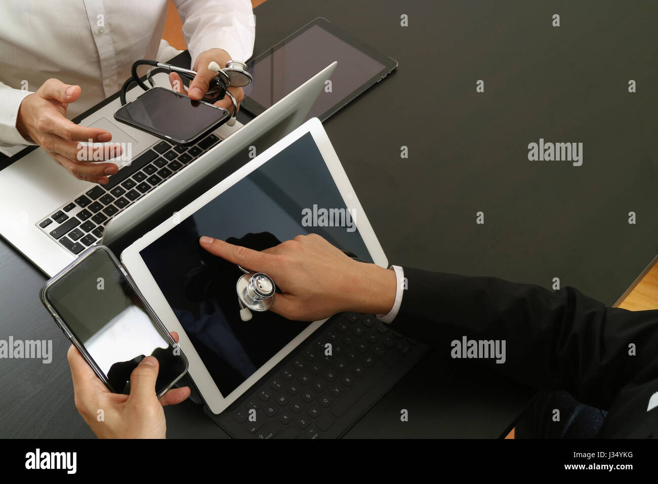 Medical co working concept,Doctor working with smart phone and digital tablet and laptop computer to meeting his team in modern office at hospital Stock Photo